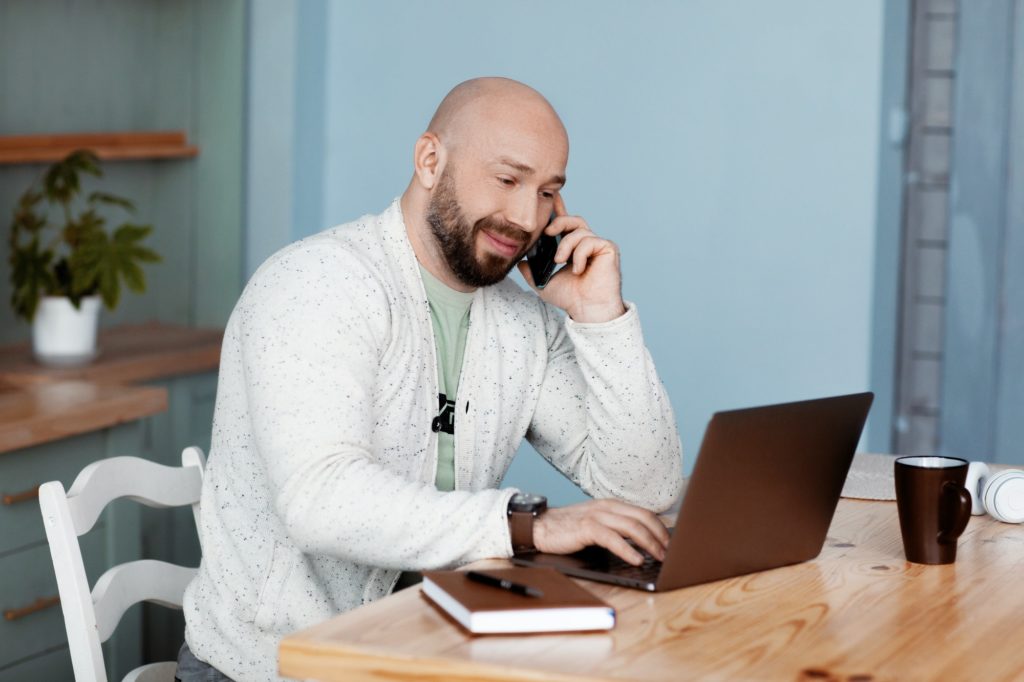 An attractive man is discussing business with business partners on the phone. Business, work